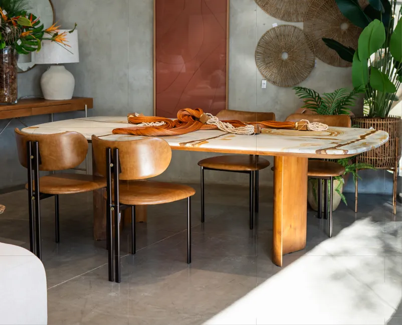 Sala decorada com sofá em L bege, mesas de centro em madeira e quadros abstratos ao fundo.